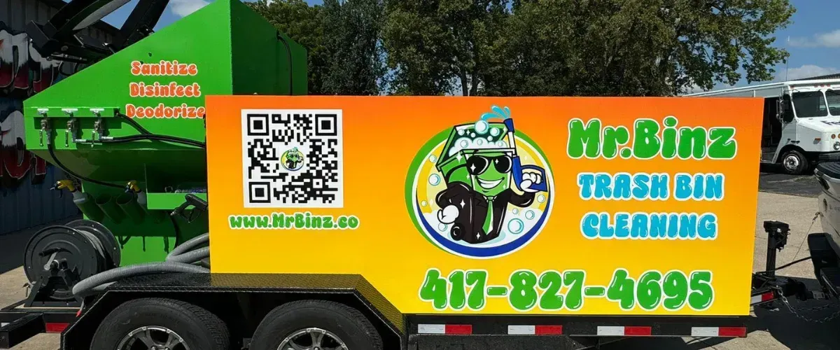 Mr. Binz trash bin cleaning service trailer with bright orange and yellow branding and QR code