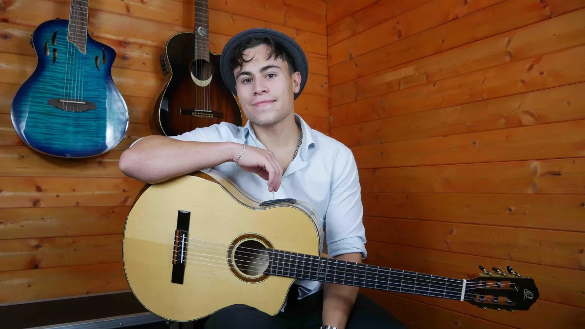 Billy Watman holding acoustic classical guitar