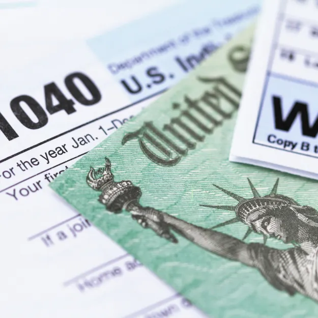 person holding black red yellow and green round analog clock