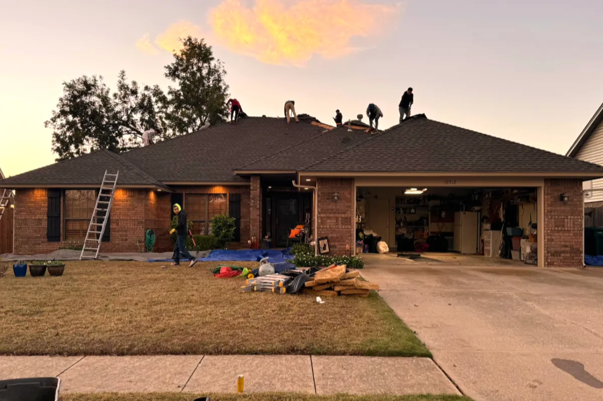 Roofing Contractors completing a full roof replacement under a beautiful Oklahoma sunrise
