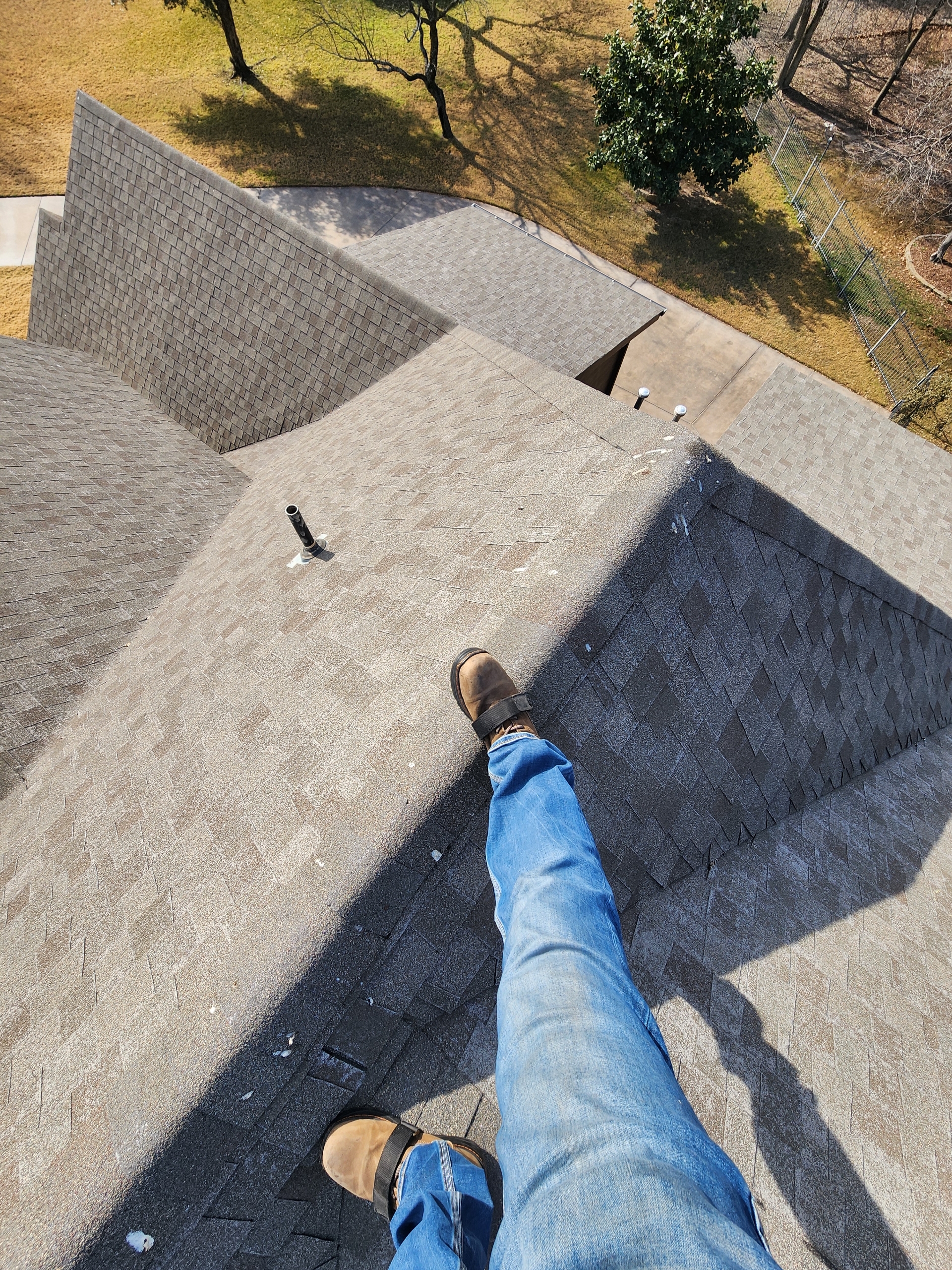 Michael inspecting a residential roof with safety harness