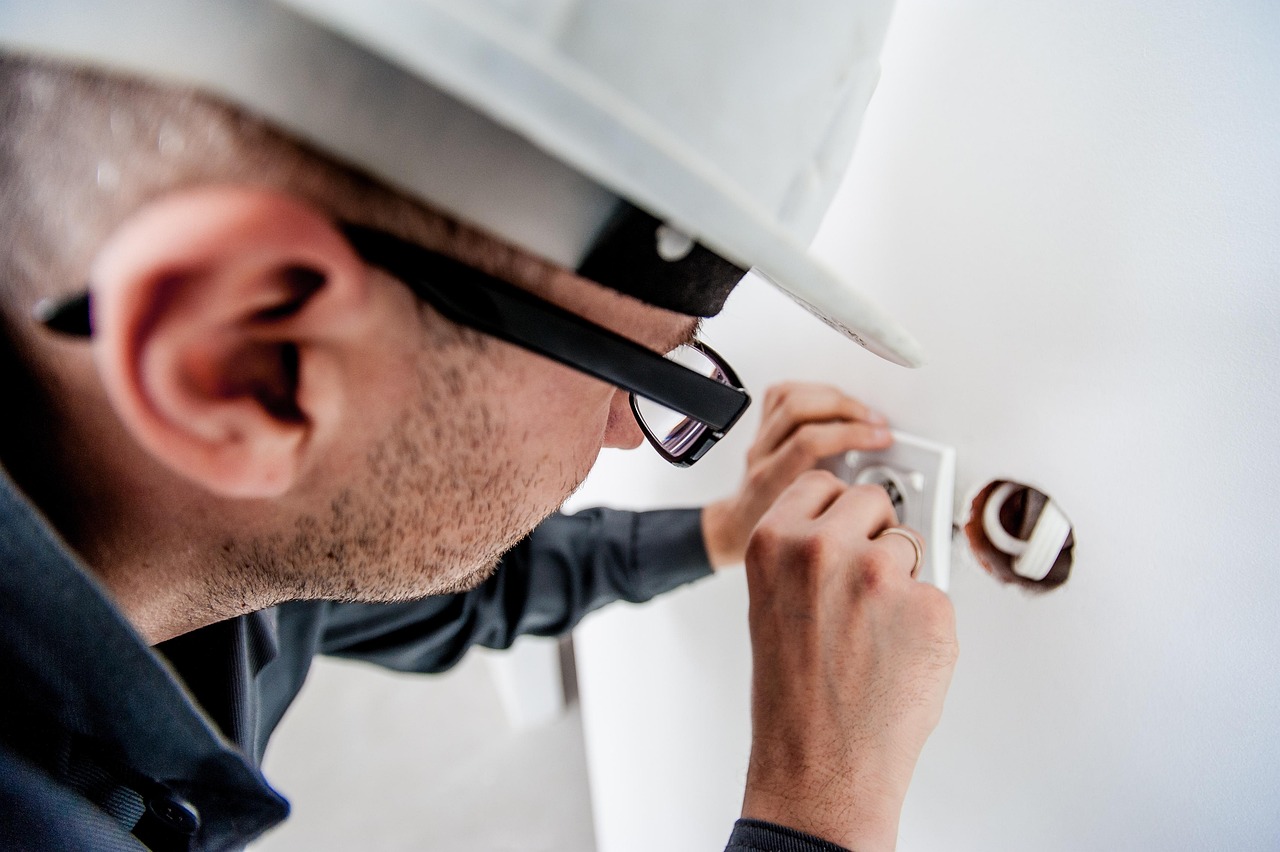 Electrician repairing a wall fitting