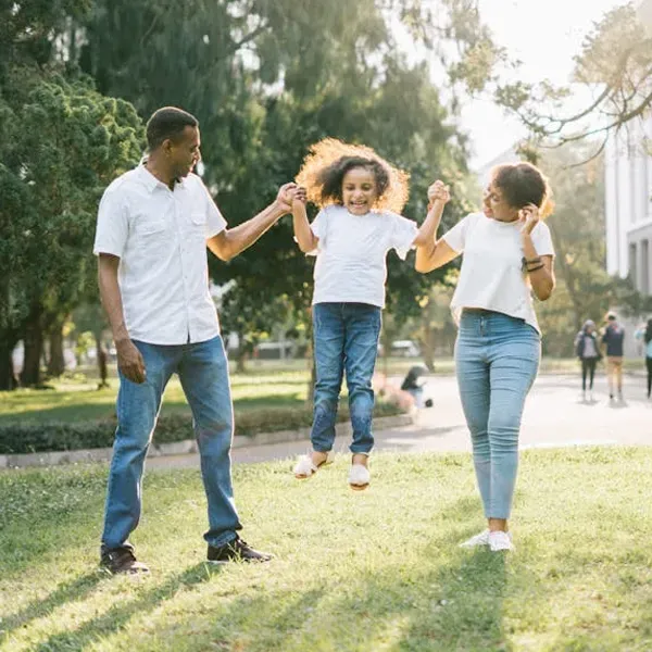 family posing and smiling for the camera infront of their home in the autumn