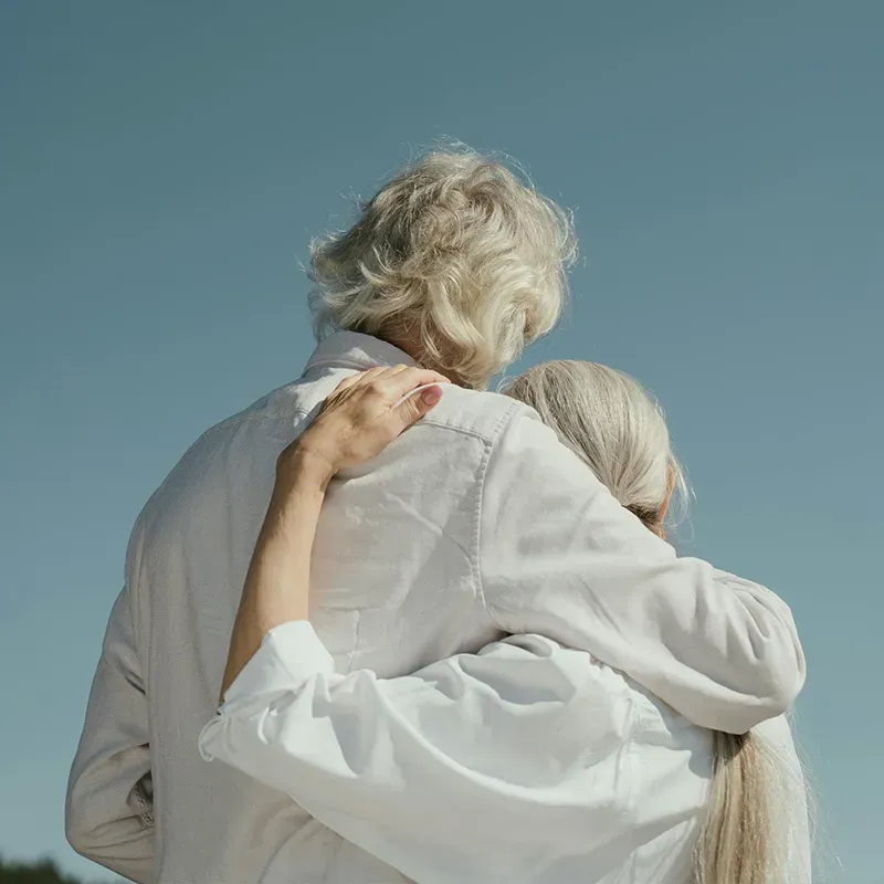 retired couple sitting on a sofa together smiling