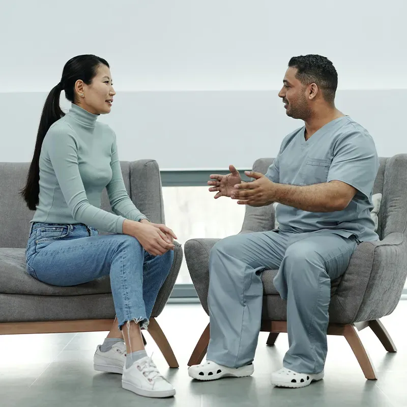 family posing and smiling for the camera infront of their home in the autumn