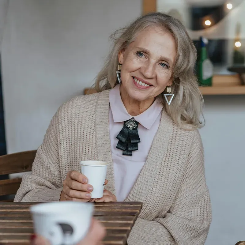 family posing and smiling for the camera infront of their home in the autumn