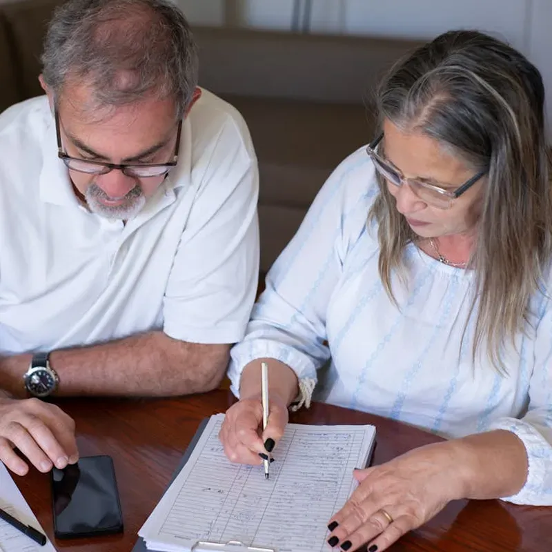 family posing and smiling for the camera infront of their home in the autumn