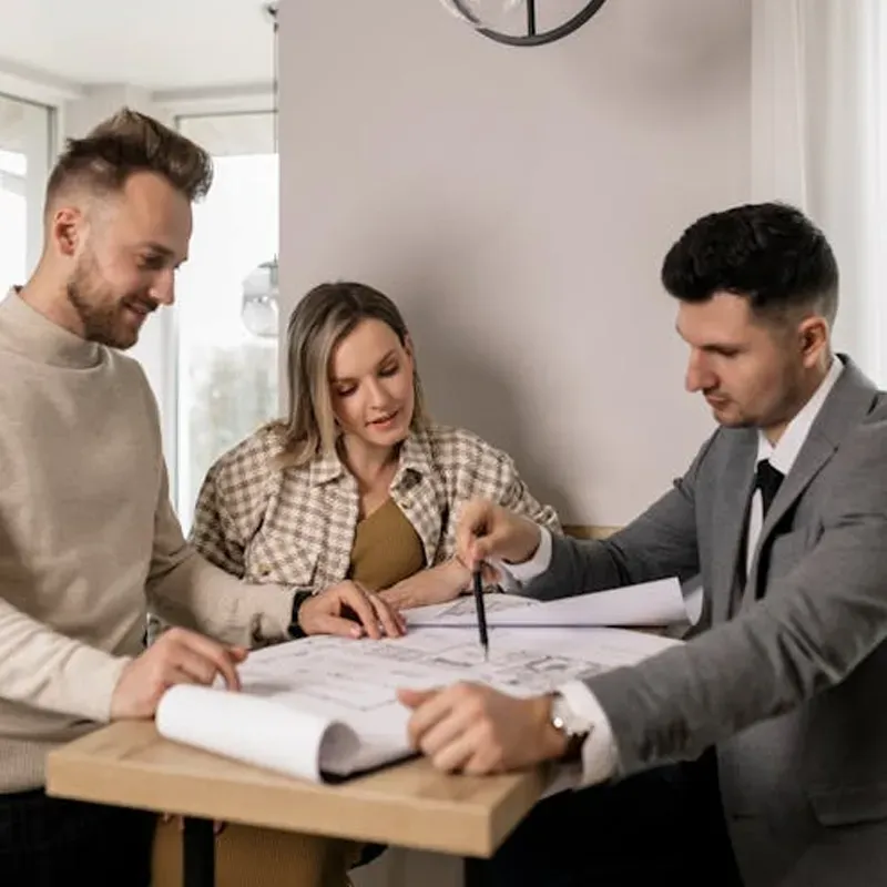 family posing and smiling for the camera infront of their home in the autumn