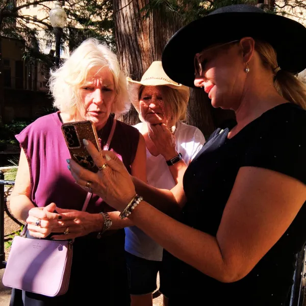 Tour guide shows cell phone images for more historical information