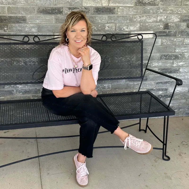 Christian mom and founder Kayla James sitting on a bench, creator of The Organized Mompreneur