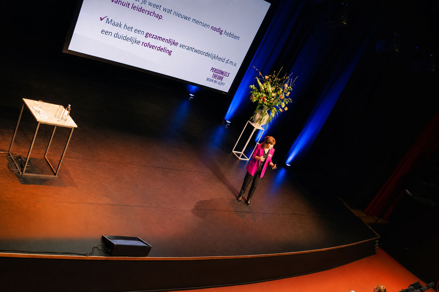 Kirsten de Roo spreekt op het podium voor een volle congreszaal