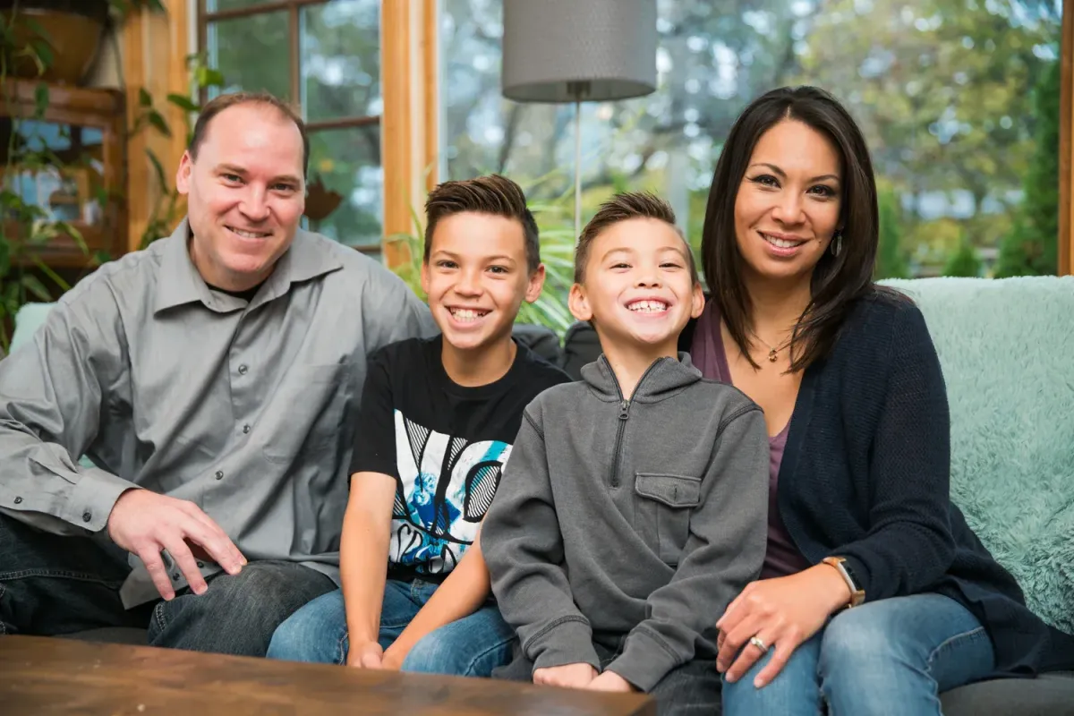 Happy father, mother and two sons sitting and smiling