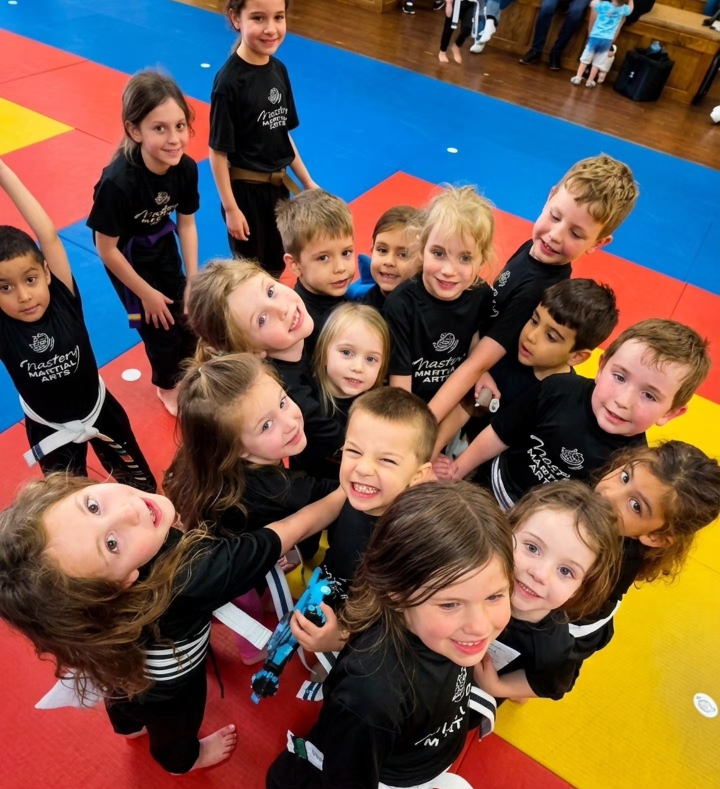 group of smiling martial arts students building confidence, friendships, and leadership skills in class