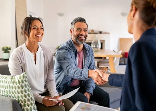 an easy close home buyers agent shaking hands with two home owners and making a deal 