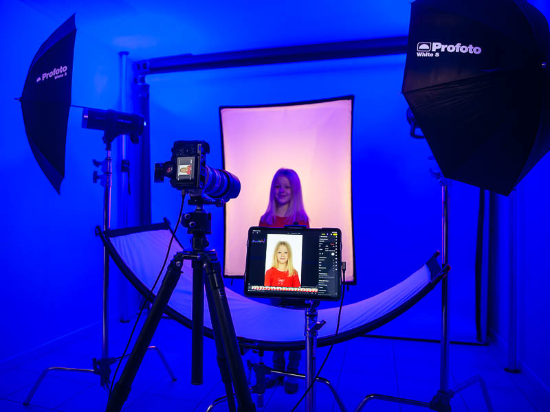 Photographer reviewing passport photo on screen with client at Gold Coast studio