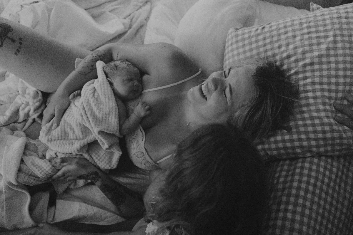 Mother holding her newborn skin-to-skin after home birth