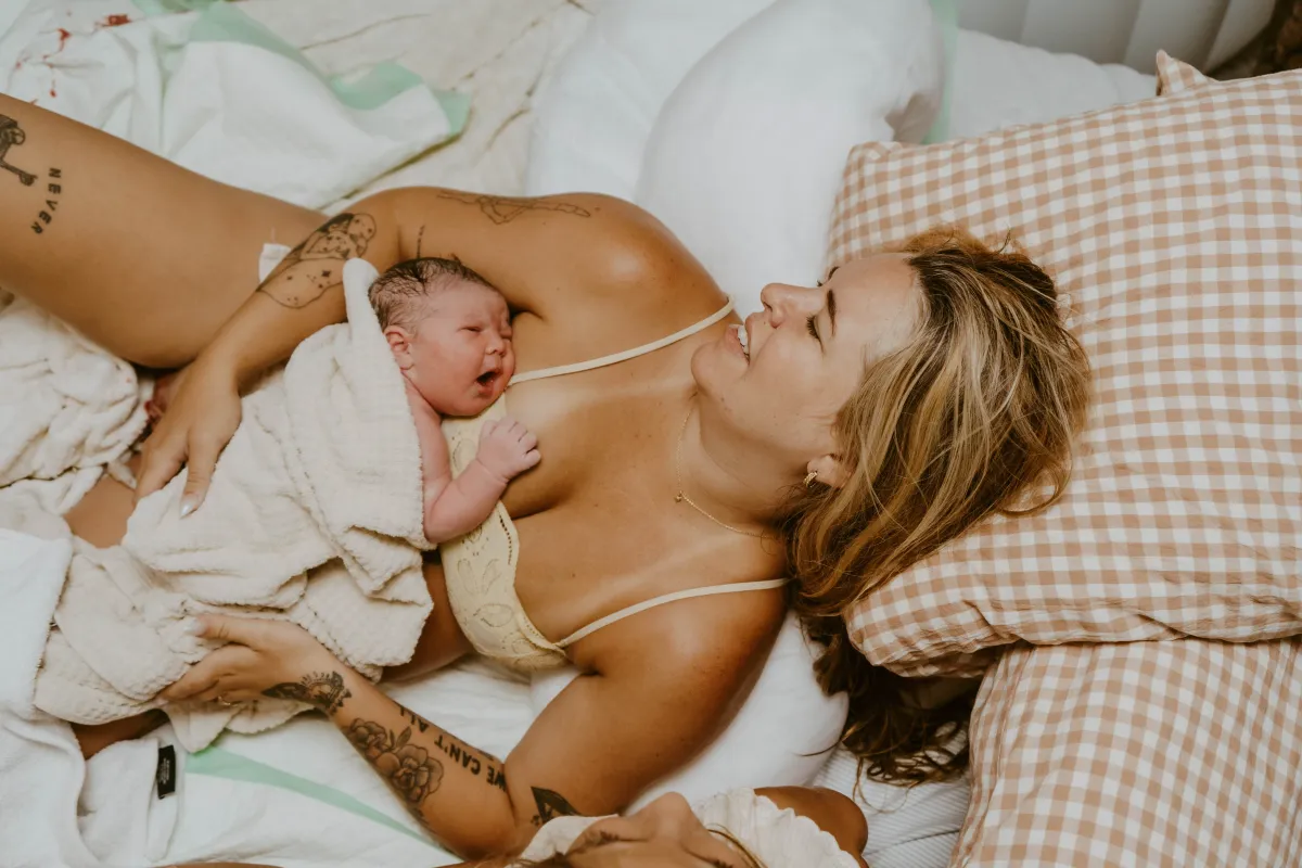 Mother holding her newborn close after home birth