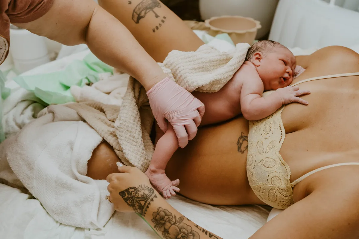 Newborn receiving gentle postpartum care while resting on mother's chest