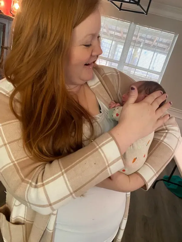 Birth support provider holding and comforting a newborn baby