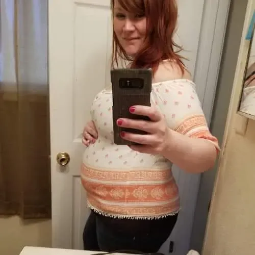 Pregnant woman taking a mirror photo during pregnancy