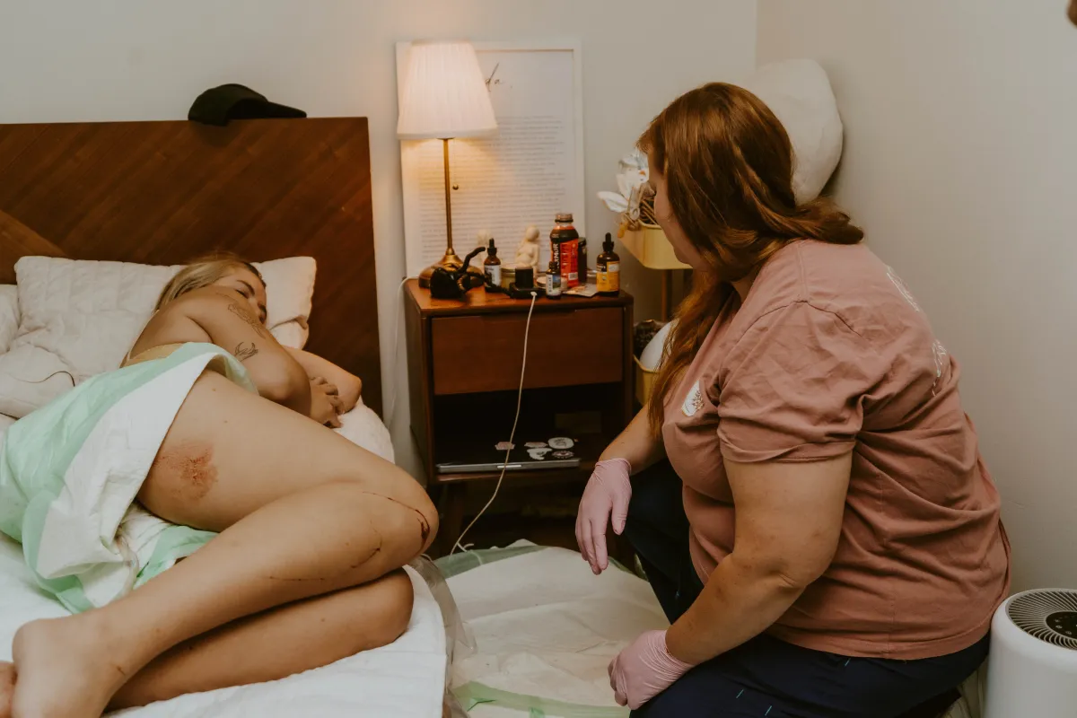 Birth support provider caring for a laboring mother during home birth