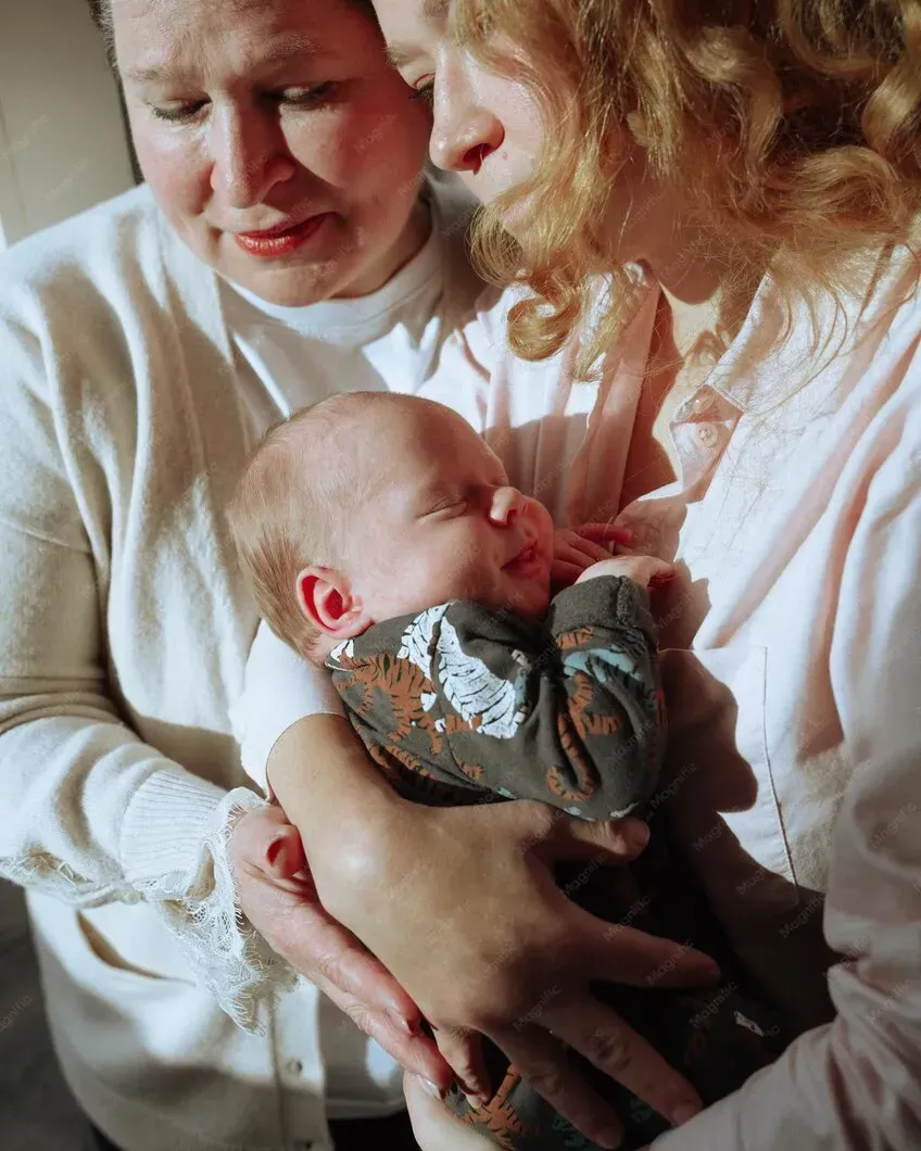 Mother holding her newborn while receiving support at home in Griffin, GA