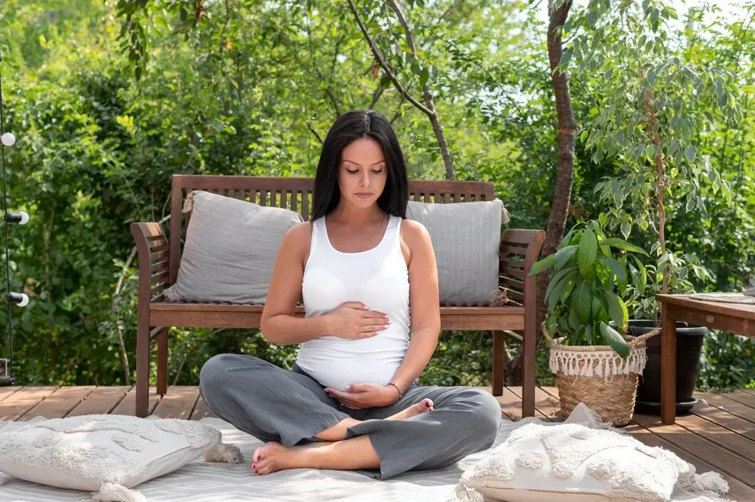 Pregnant woman practicing peaceful holistic pregnancy care outdoors during home birth preparation in Newnan, GA
