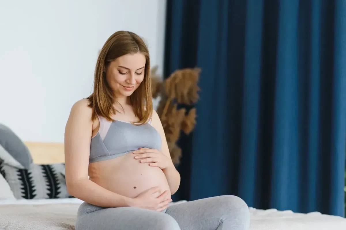 Pregnant woman sitting comfortably at home while preparing for motherhood