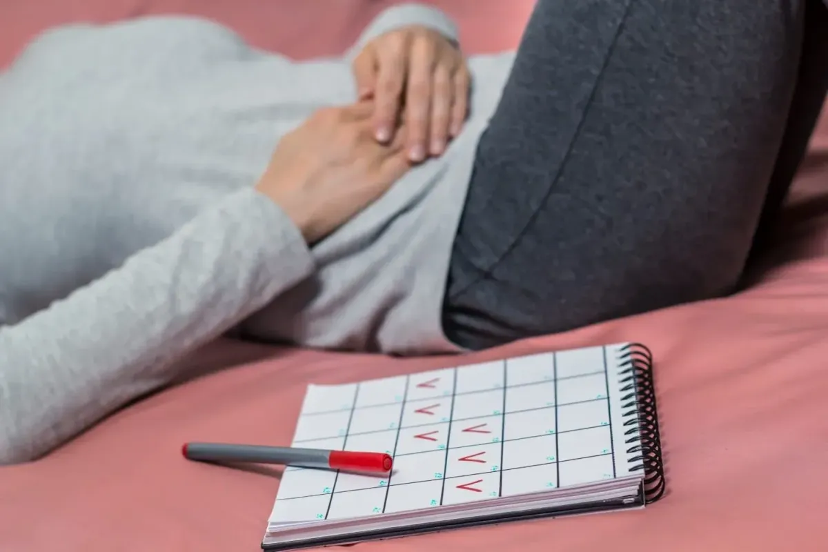 Woman experiencing abdominal discomfort while tracking her menstrual cycle