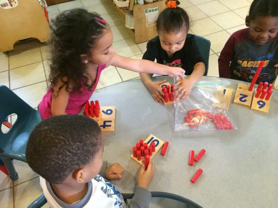 four kids learning to count with pegs