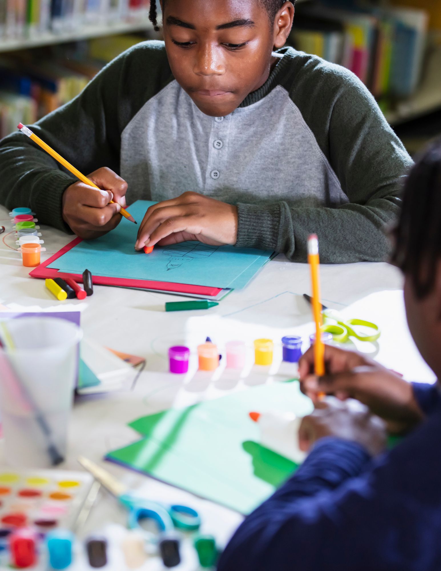 Child with headset smiles as he engages with laptop