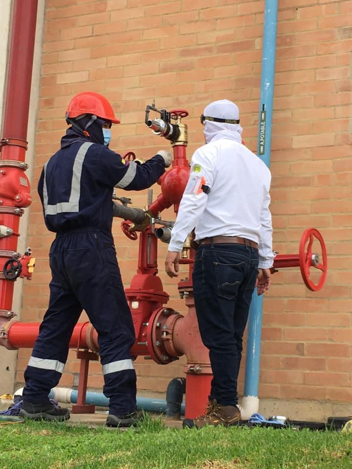 Hands using a digital caliper to measure metal part.