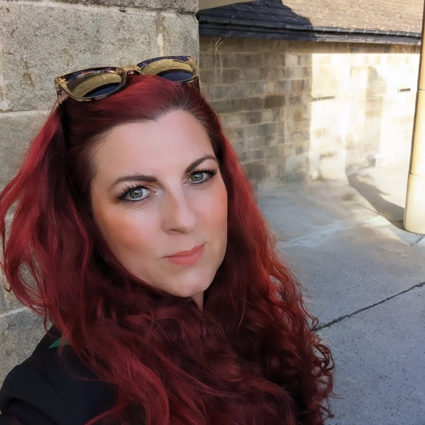 Nikkola Wright founder of Rebel or Business, red hair, sunglasses on her head looking direct at the camera