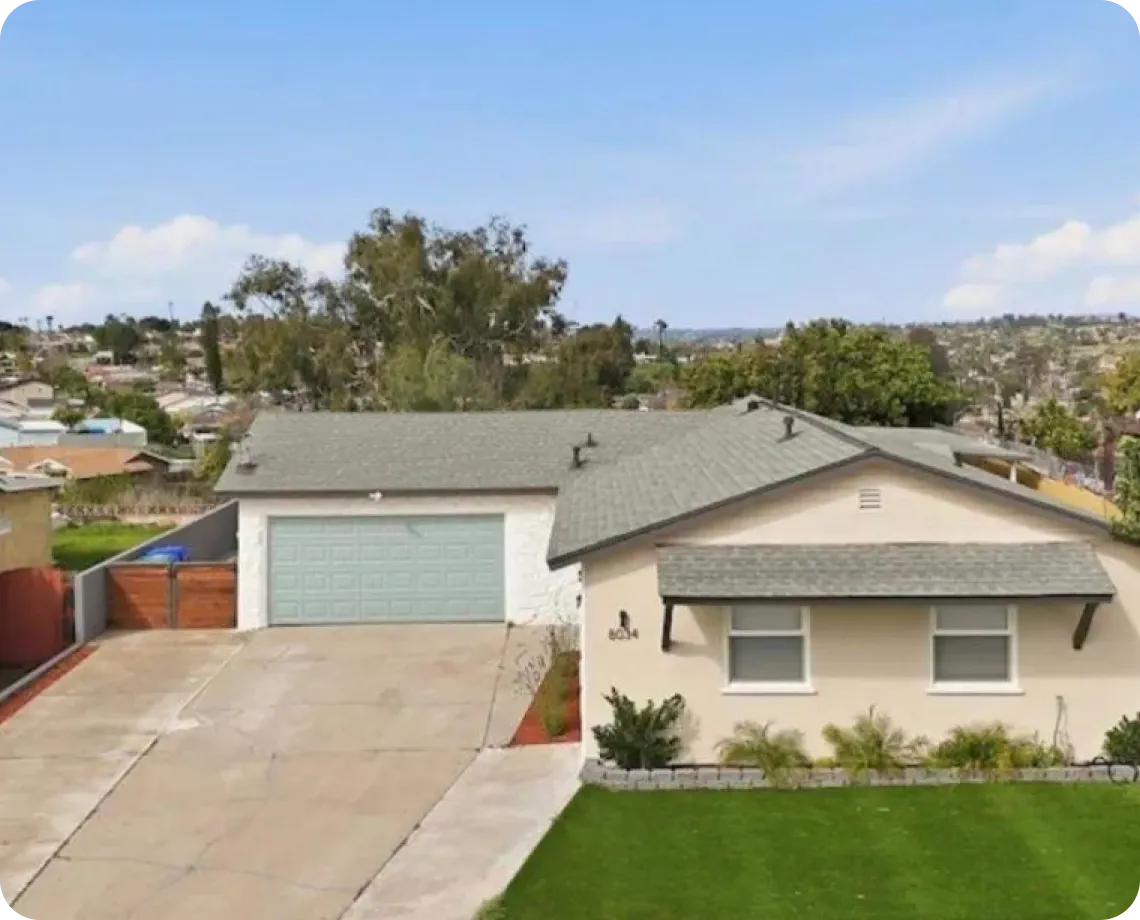 A modest single-story house with a green lawn.