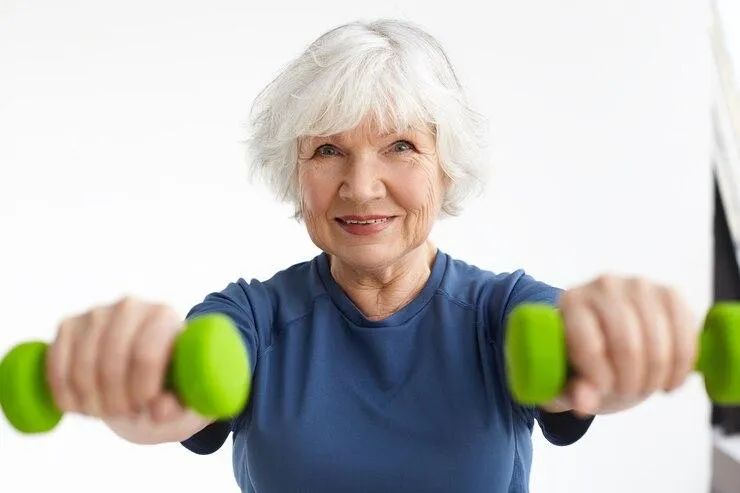 A woman squats while using a resistance band, demonstrating strength training and fitness in a gym setting