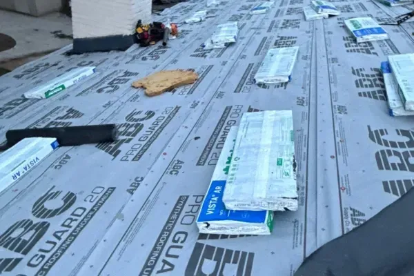 Roof prepared with ABC Pro Guard 20 underlayment and shingle bundles ready for installation.