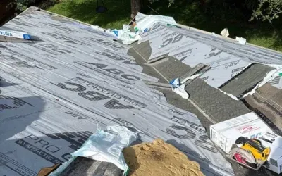 Roofing underlayment installation with ABC Pro Guard synthetic material before shingle placement.