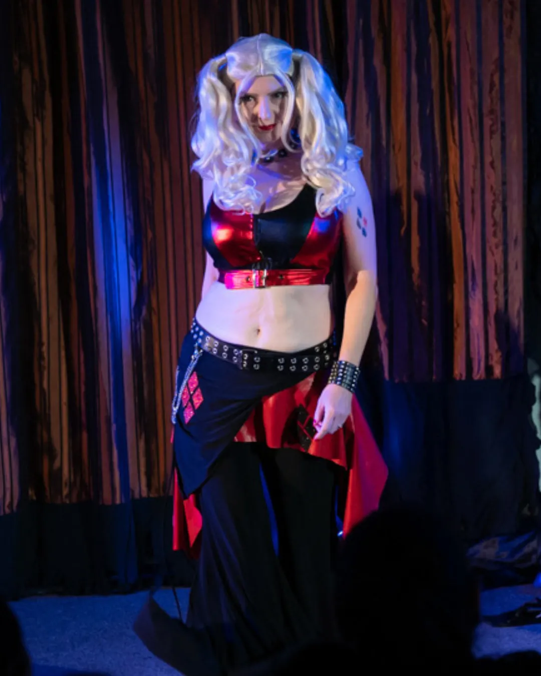 Deana performing as Harley Quinn in red and black costume