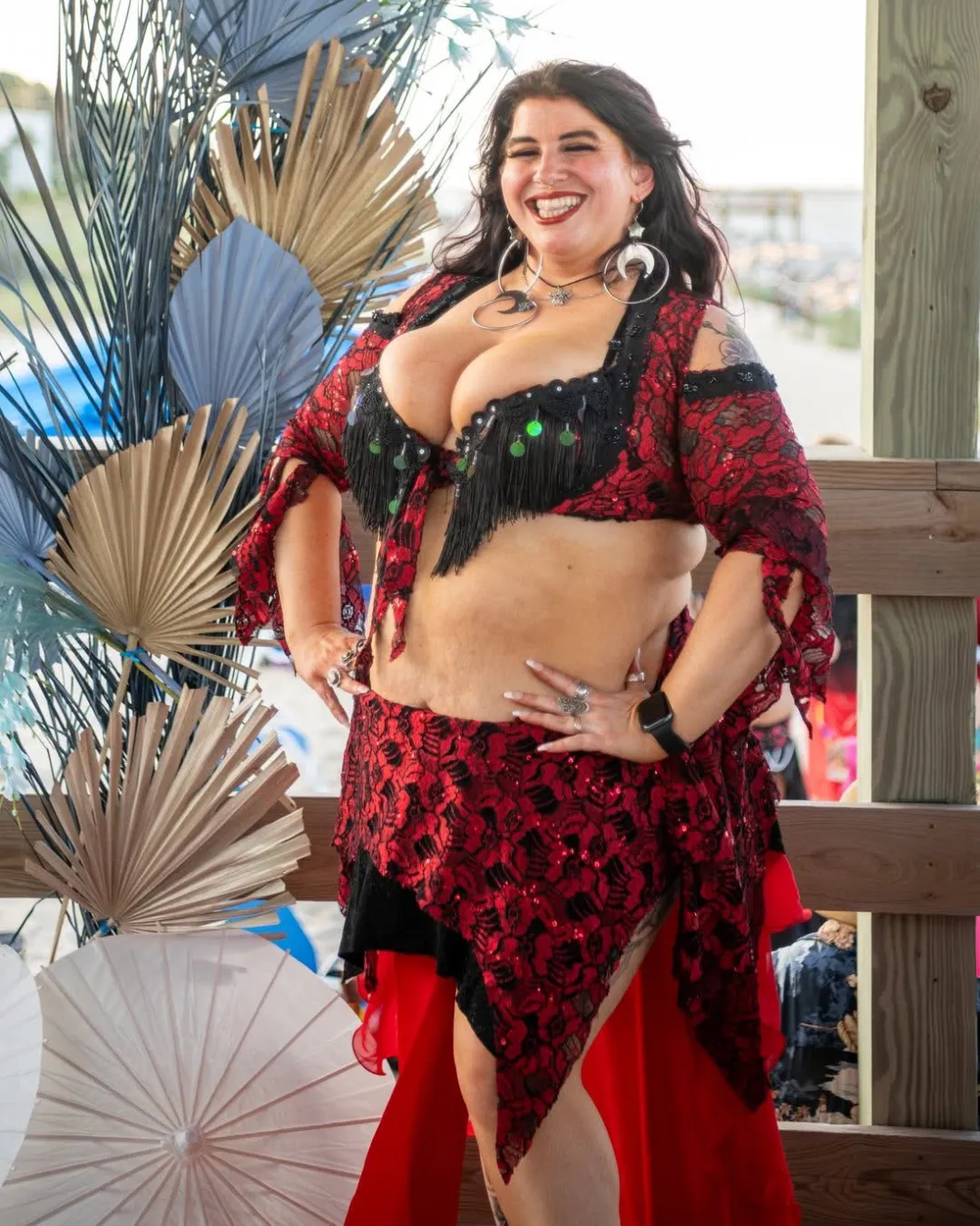 Naturally Morbid smiling at the beach in red and black costume