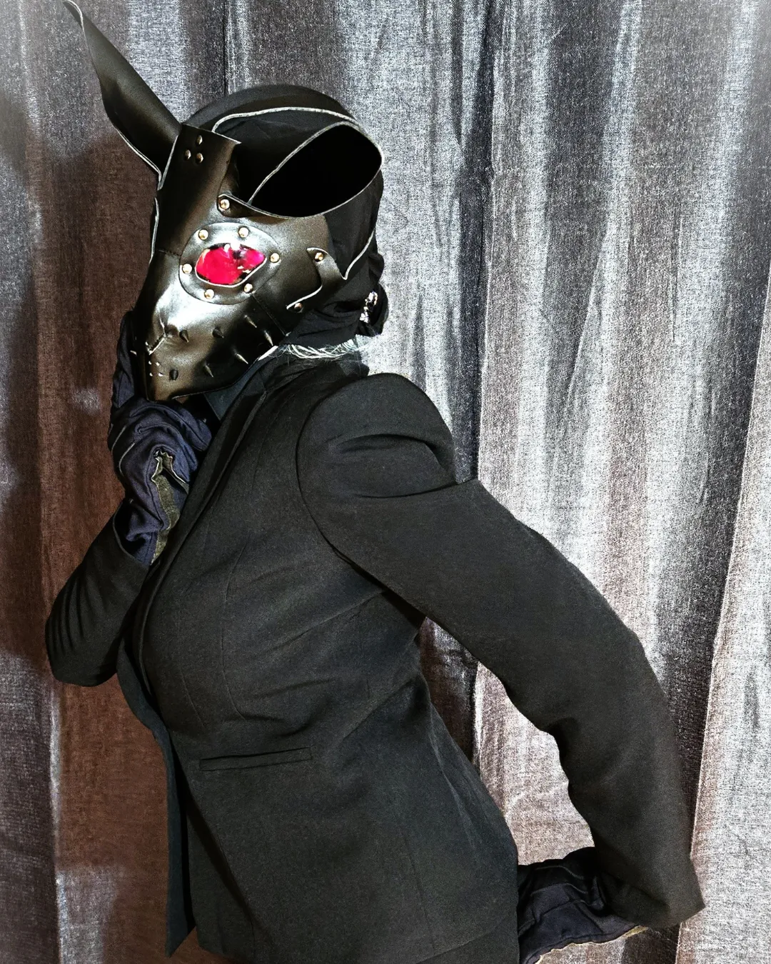 Lillith Engur in a black suit and rabbit mask
