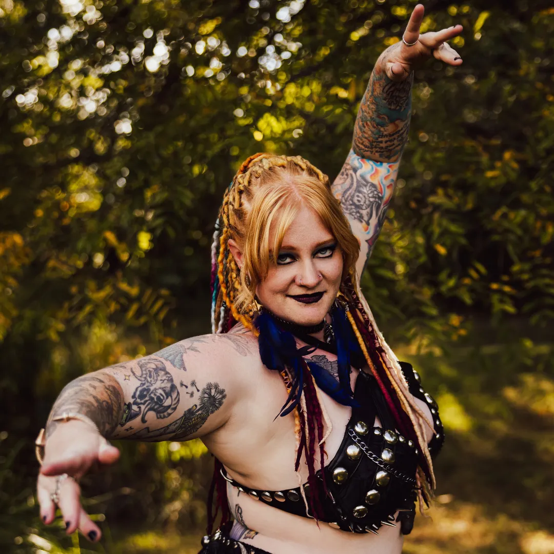 Daewen confident dancer pose with dreadlocks, black costume, and tattoos