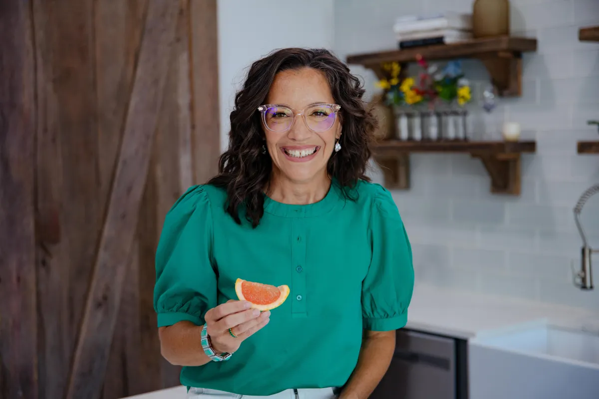 Registered Dietitian holding pink grapefruit in beautiful kitchen