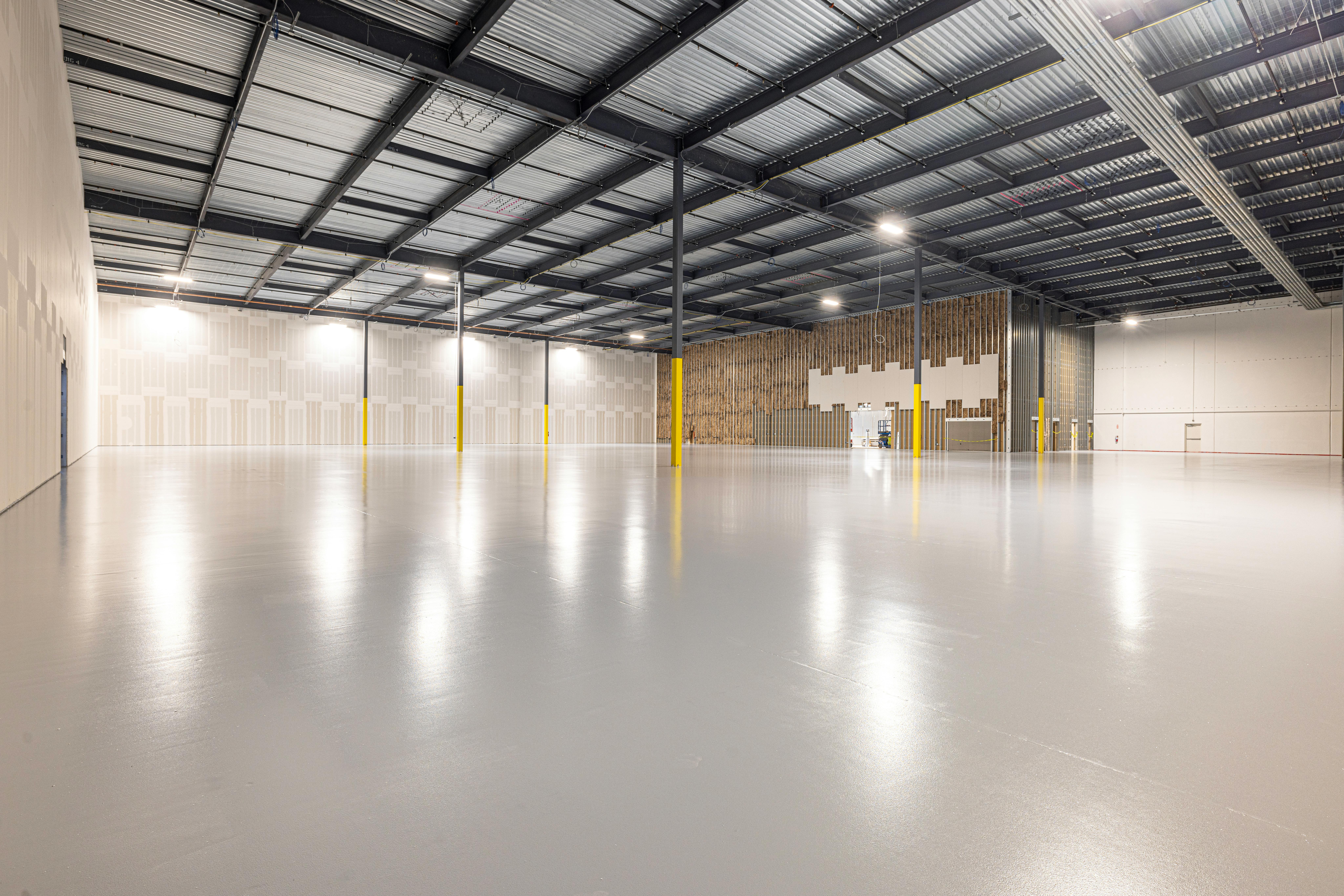 empty warehouse with white floor and metal ceiling