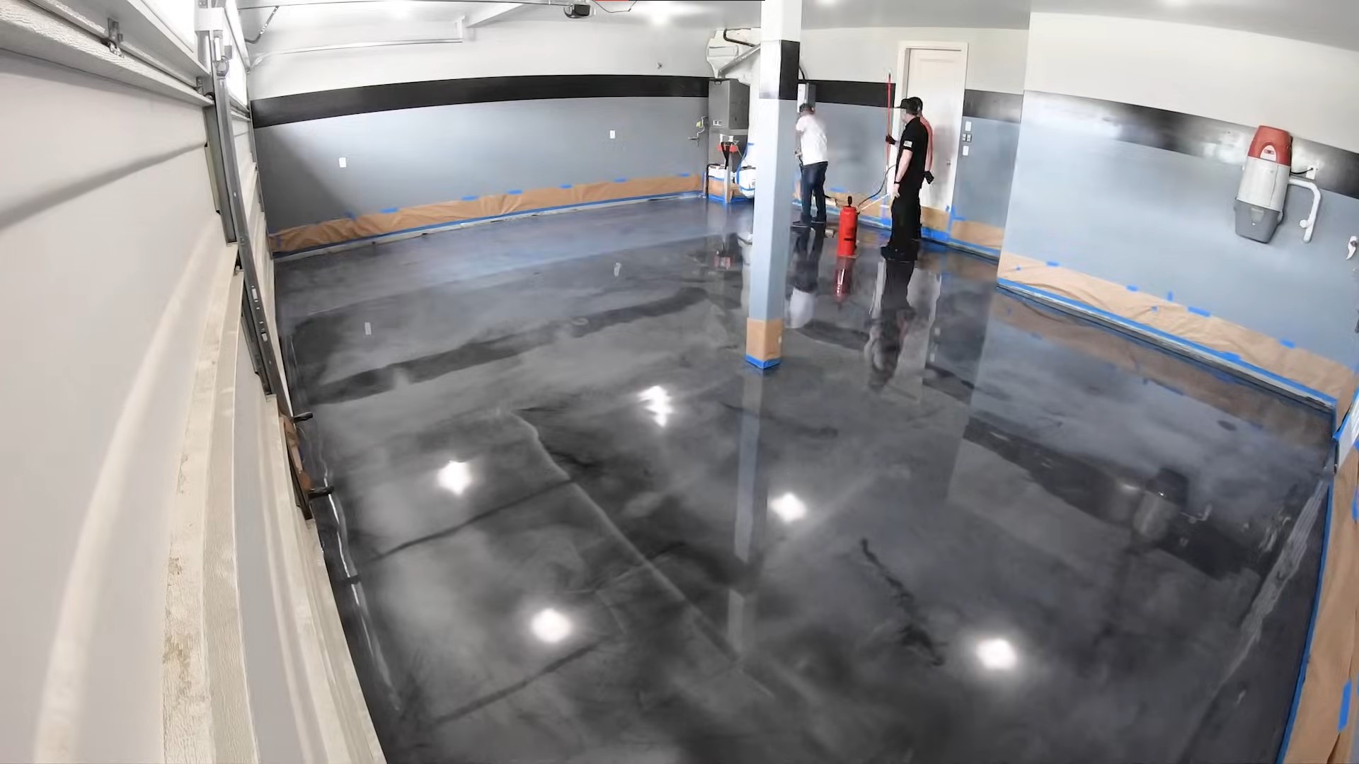 two people on a black epoxy floor in garage