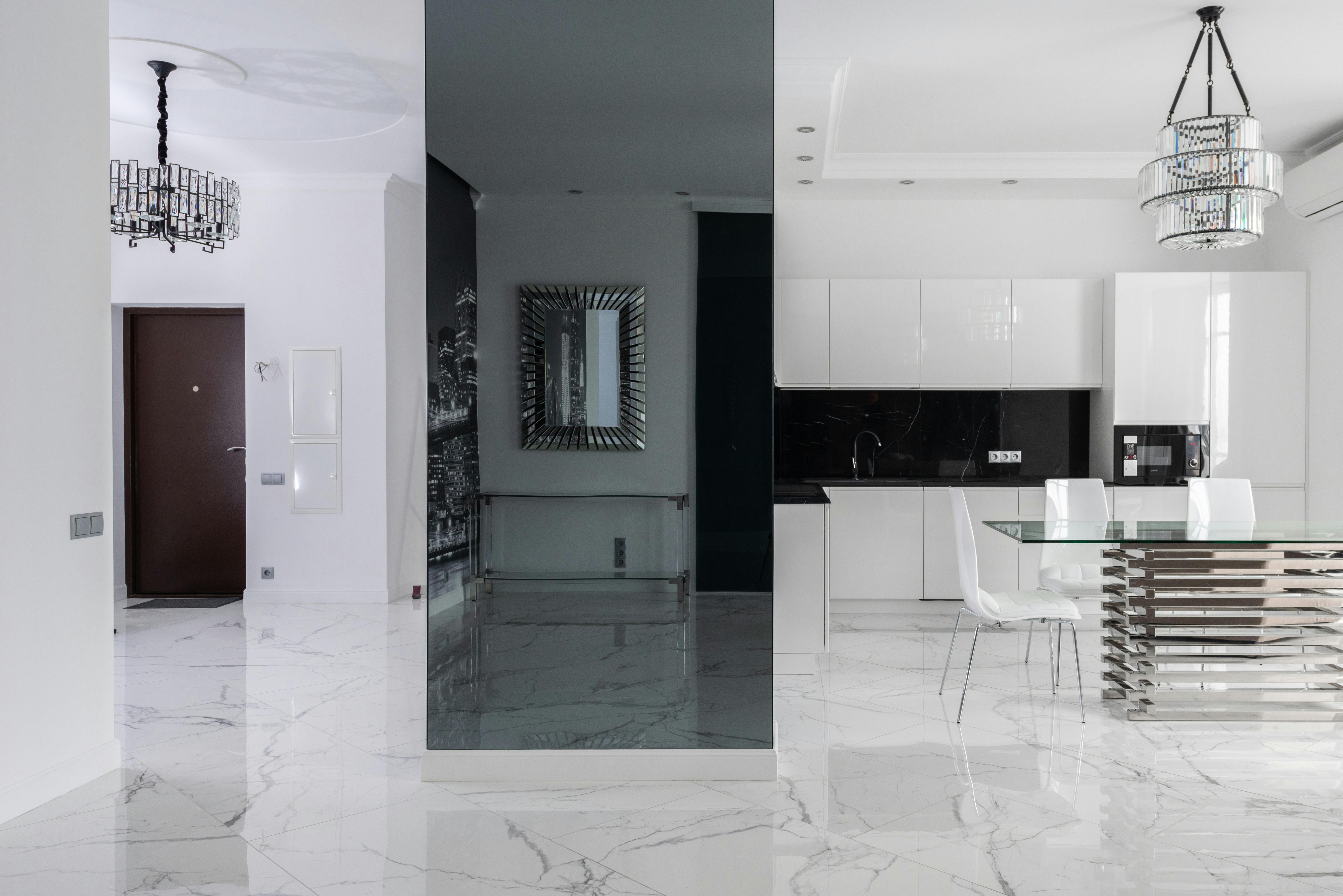 marble white themed living room with chair and table, and chandeliers
