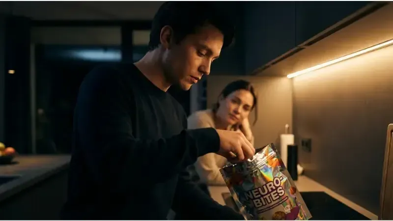 Why is sugar so addictive. Man opens a bag of sweets while a woman watches from the background.