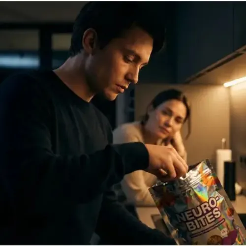 Why is sugar so addictive. Man opens a bag of sweets while a woman watches from the background.