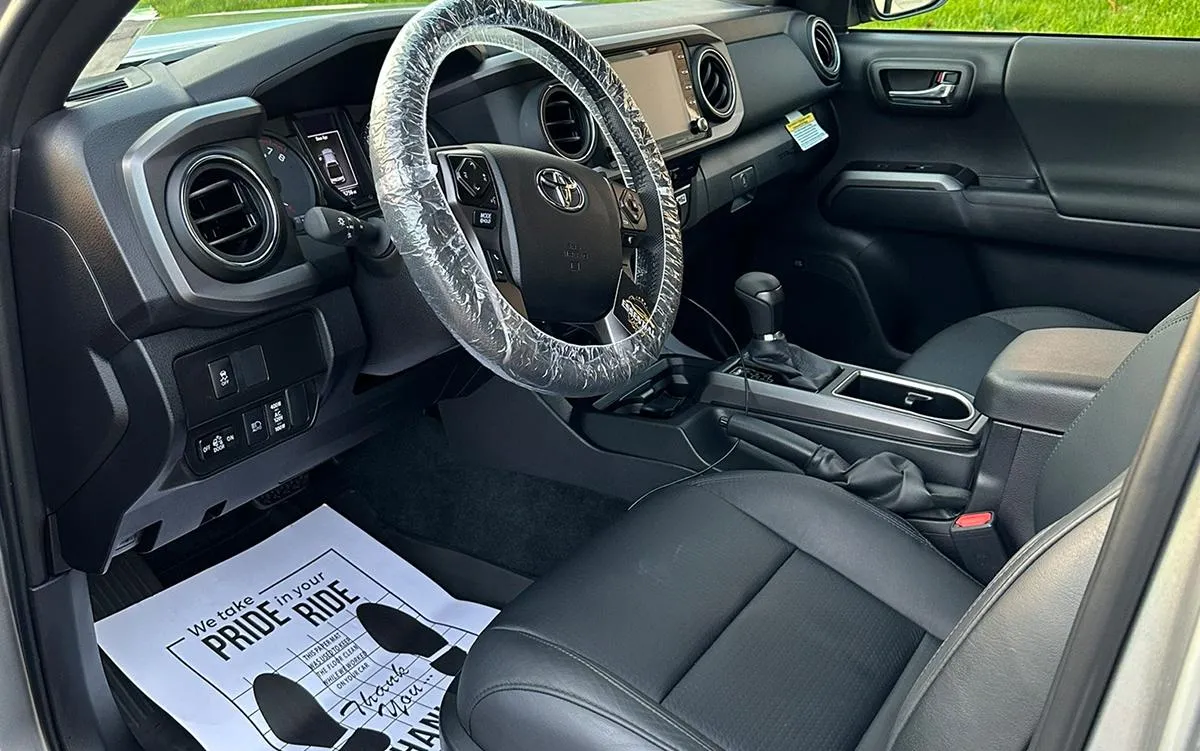 An individual spraying the interior of a car with a cleaning solution