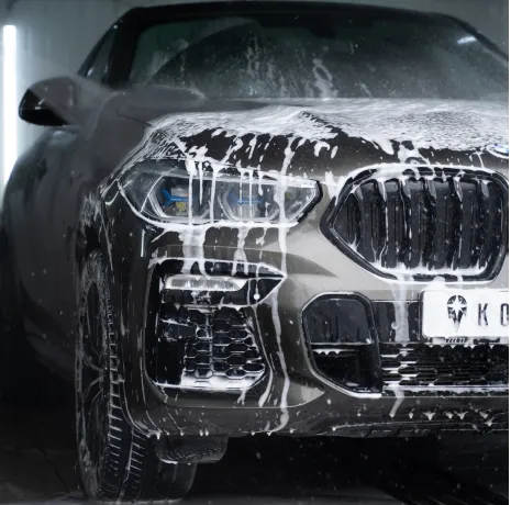 A black car washed by water and soap