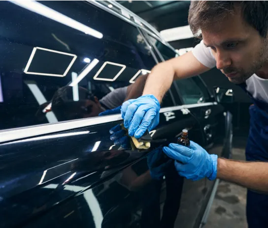 A man applying a ceramic coat on a car